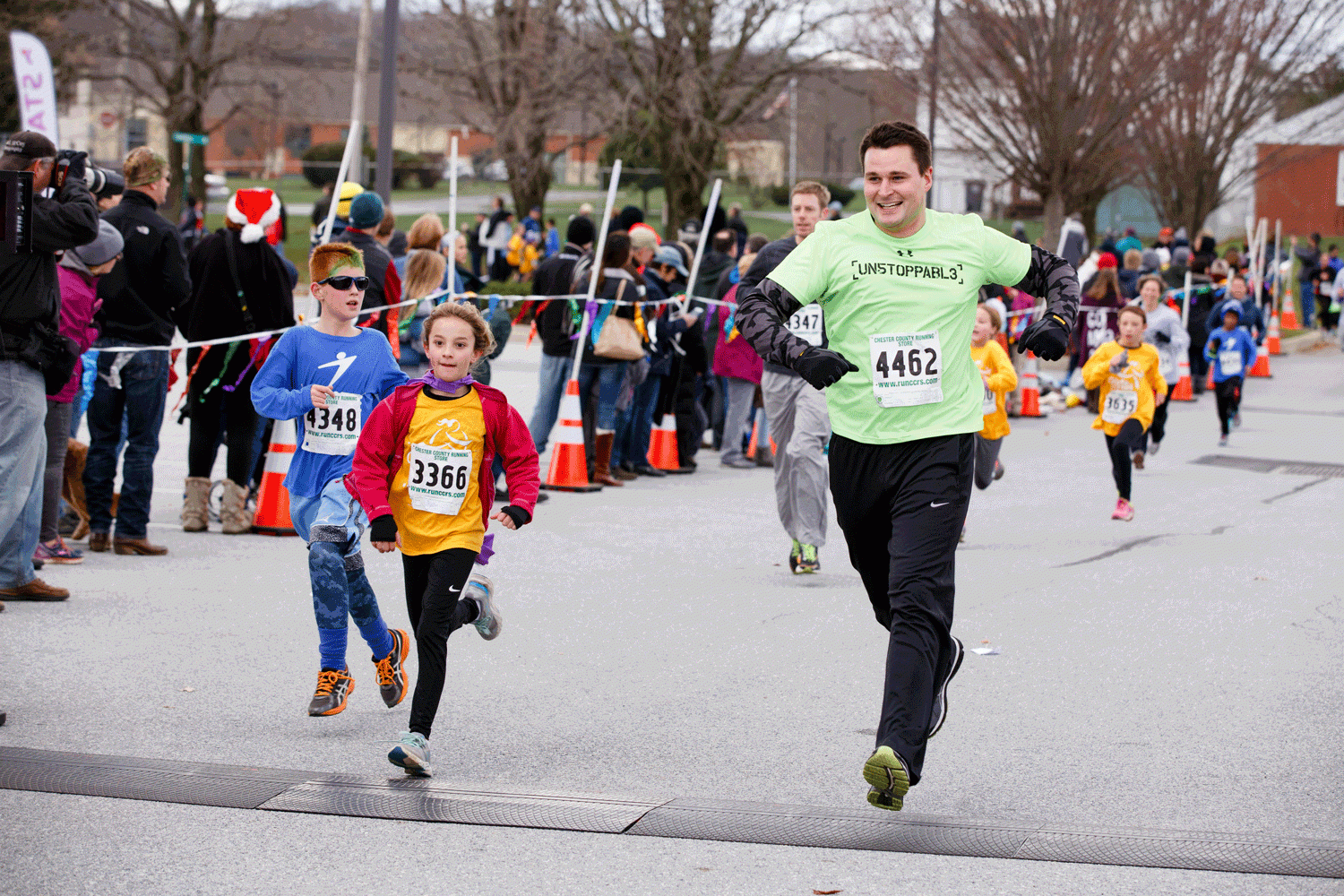 A STRIDE and Girls on the Run participant crosses the finish line for the 5K with their running buddy.