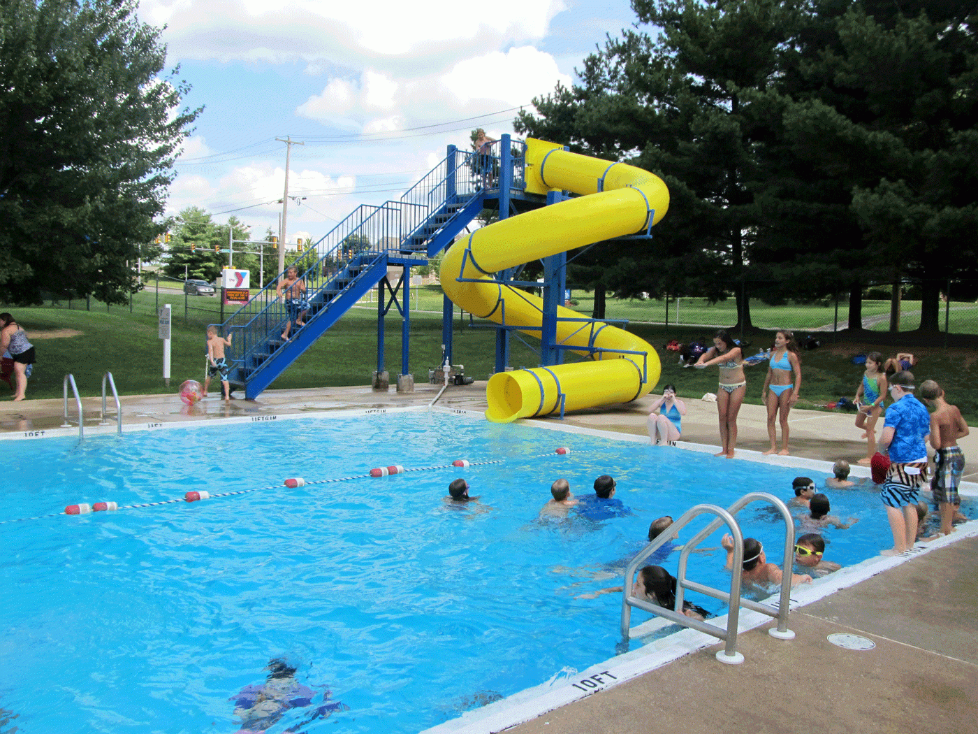 Kids enjoy the outdoor swimming pool and water slide at the Jennersville YMCA in West Grove PA