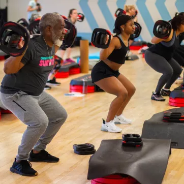 Family Lifts Barbell in BODYPUMP Class