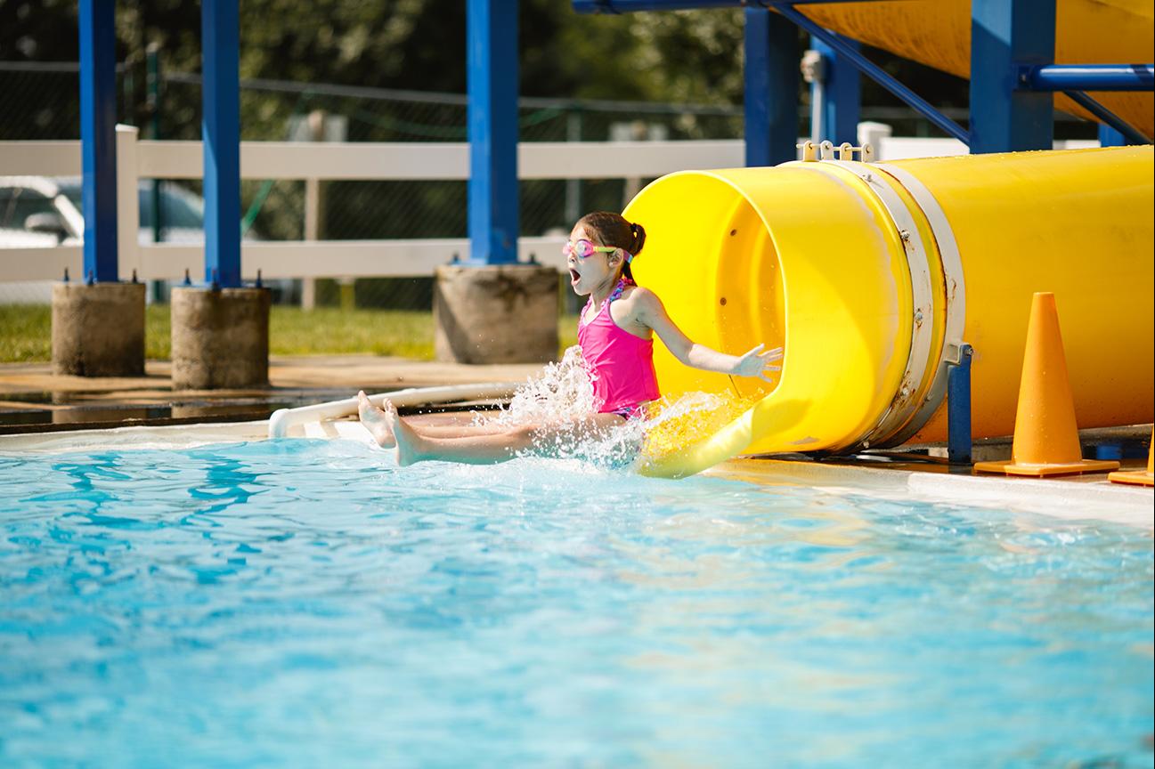 A child goes down the water slide at the Brandywine YMCA outdoor swimming pool