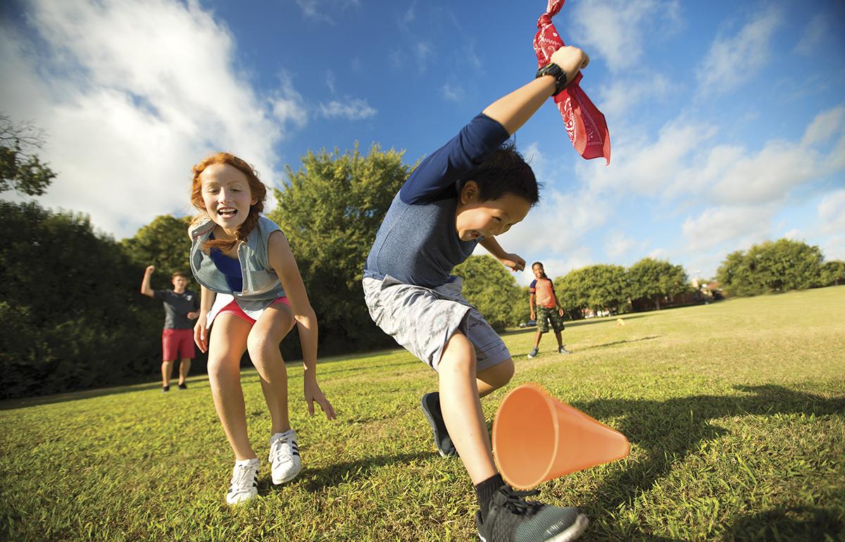 A boy and girl play outside during camp at the YMCA. 
