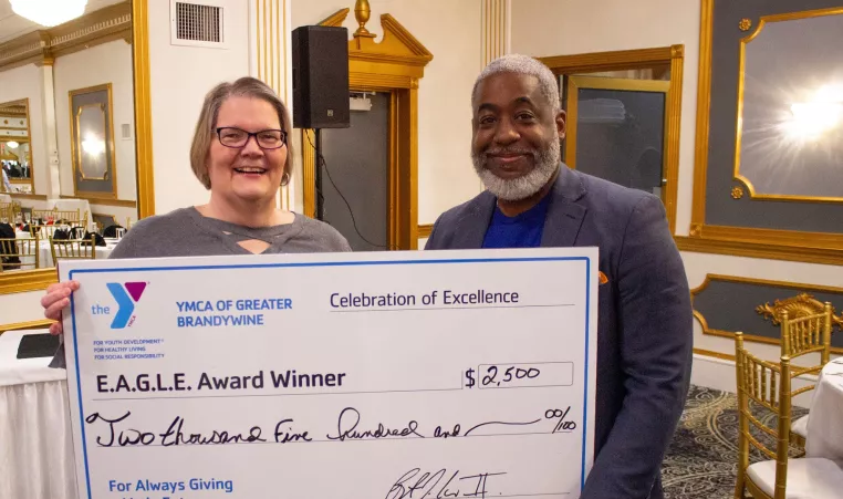 Bertram L. Lawson II, President and CEO of the YMCA of Greater Brandywine, presents the E.A.G.L.E. award to Dawn Bennett, Payroll and Benefits Administrator.