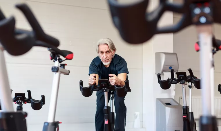 Senior man taking a cycling class at the Y