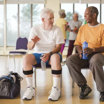 Two seniors drinking water after exercising